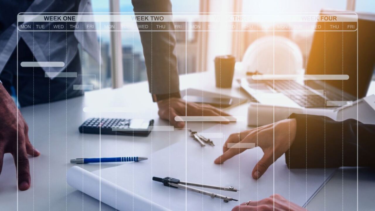 zoom su mani di persone che lavorano in ufficio. si vedono fogli, calcolatrici