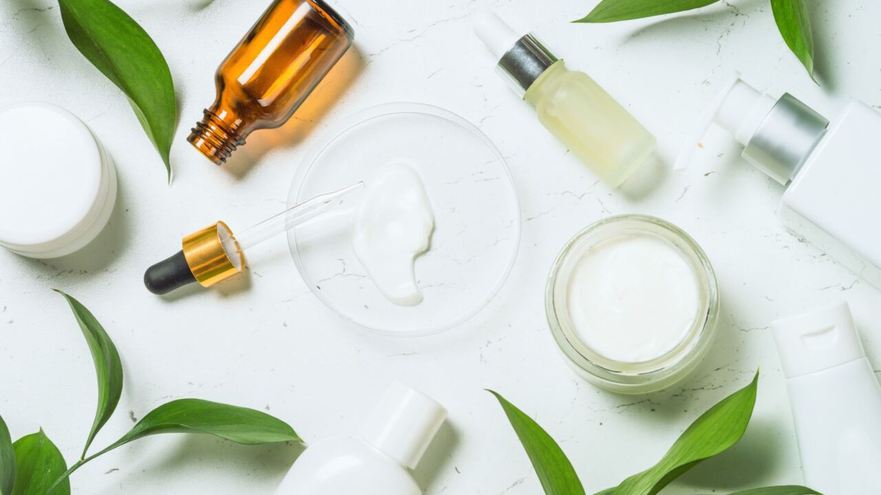 Italian cosmetics cosmetics arranged on a white table with green leaves surrounding them